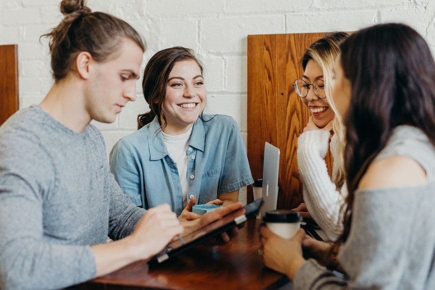 Four people gathered around a table taking notes during a research session