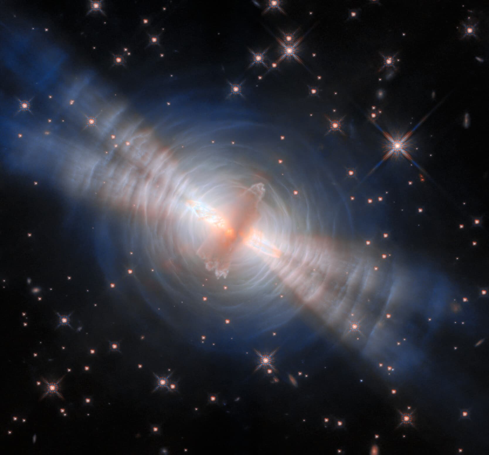 The Egg Nebula, a pre-planetary nebula, with a central dust-shrouded dying star casting symmetric searchlight beams through concentric arcs of dust.