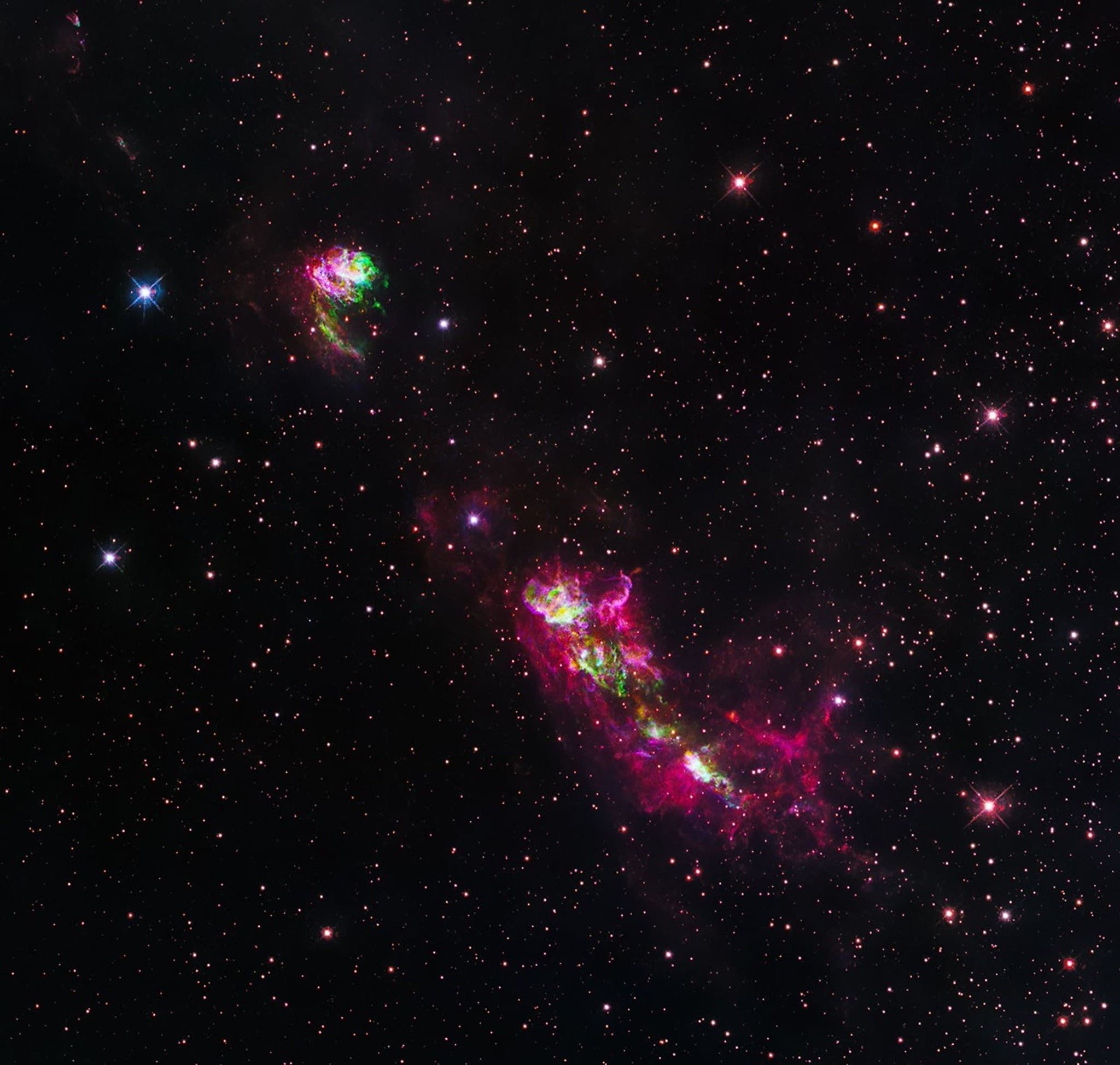 A fast protostellar jet lighting up pink and green Herbig-Haro shock knots as it plows through interstellar gas in the star-forming region HH 80/81.
