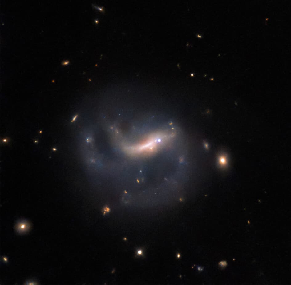 The barred spiral galaxy LEDA 857074 against the dark of space, with the bright point of a supernova shining on the right side of the galaxy's central bar.