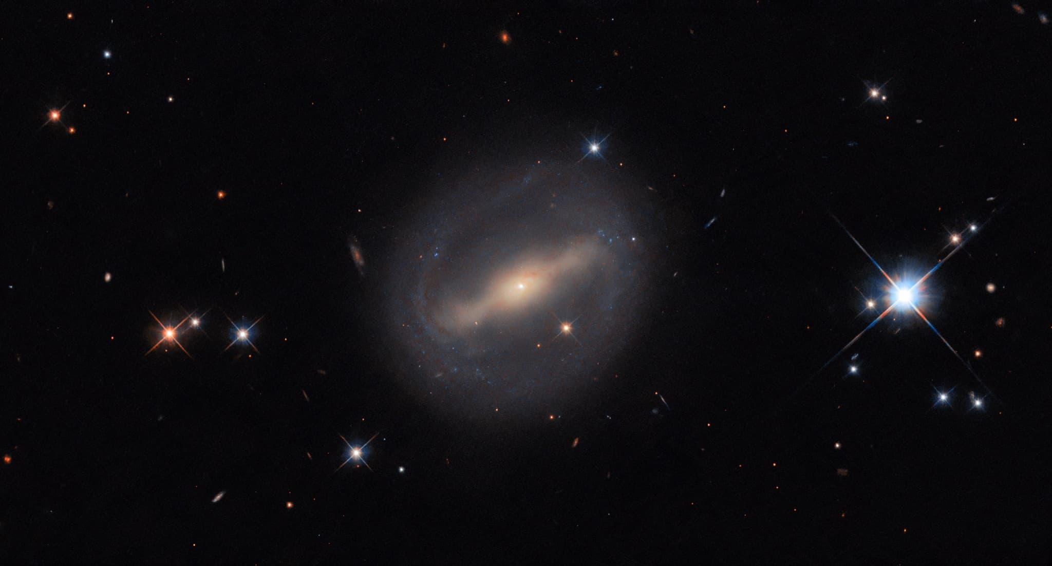 The barred spiral galaxy MCG+07-07-072, thin arms curving from the ends of its central bar into a near-complete ring around its disk.