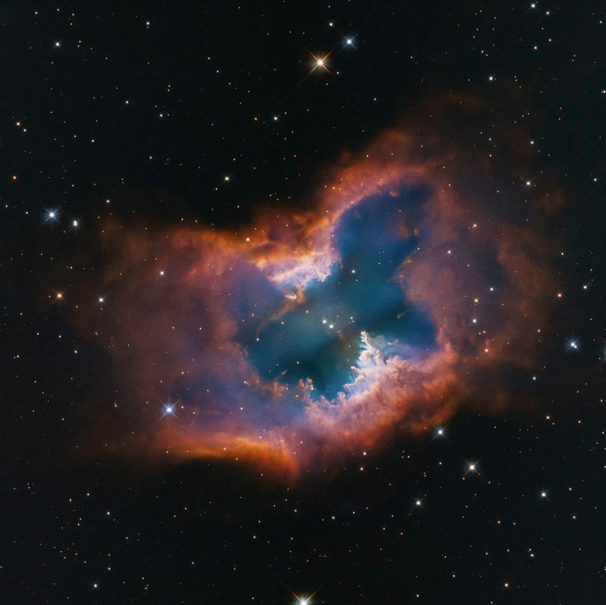 The moth-shaped bipolar planetary nebula NGC 2899, glowing pink and blue lobes of hydrogen and oxygen gas fanning out symmetrically from a hot central white dwarf.