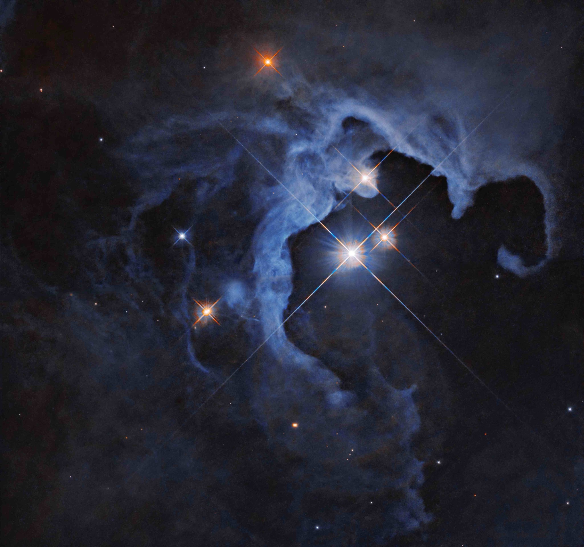 Three brilliant young stars of the HP Tau triple-star system blazing inside a hollowed-out cavity of a golden reflection nebula that curls around them like a glowing cosmic geode.