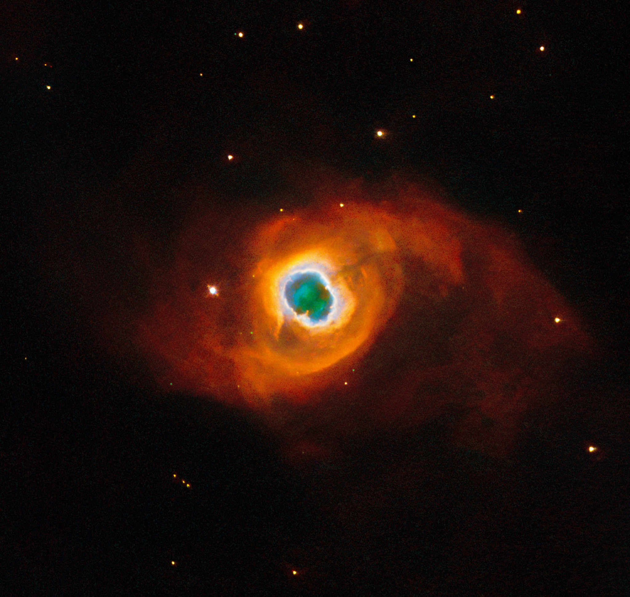 Swirling, paint-like clouds of red, green, and blue gas forming the planetary nebula Kohoutek 4-55, the glowing shell cast off by a dying star.