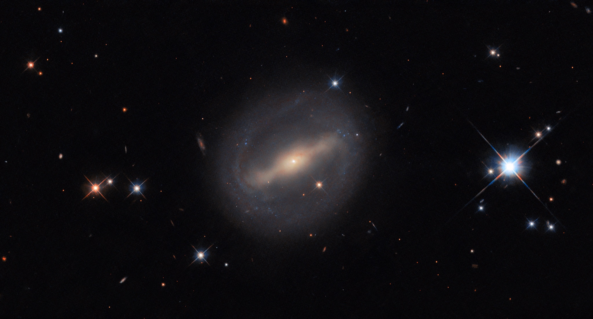 The barred spiral galaxy MCG+07-07-072, thin arms curving from the ends of its central bar into a near-complete ring around its disk.