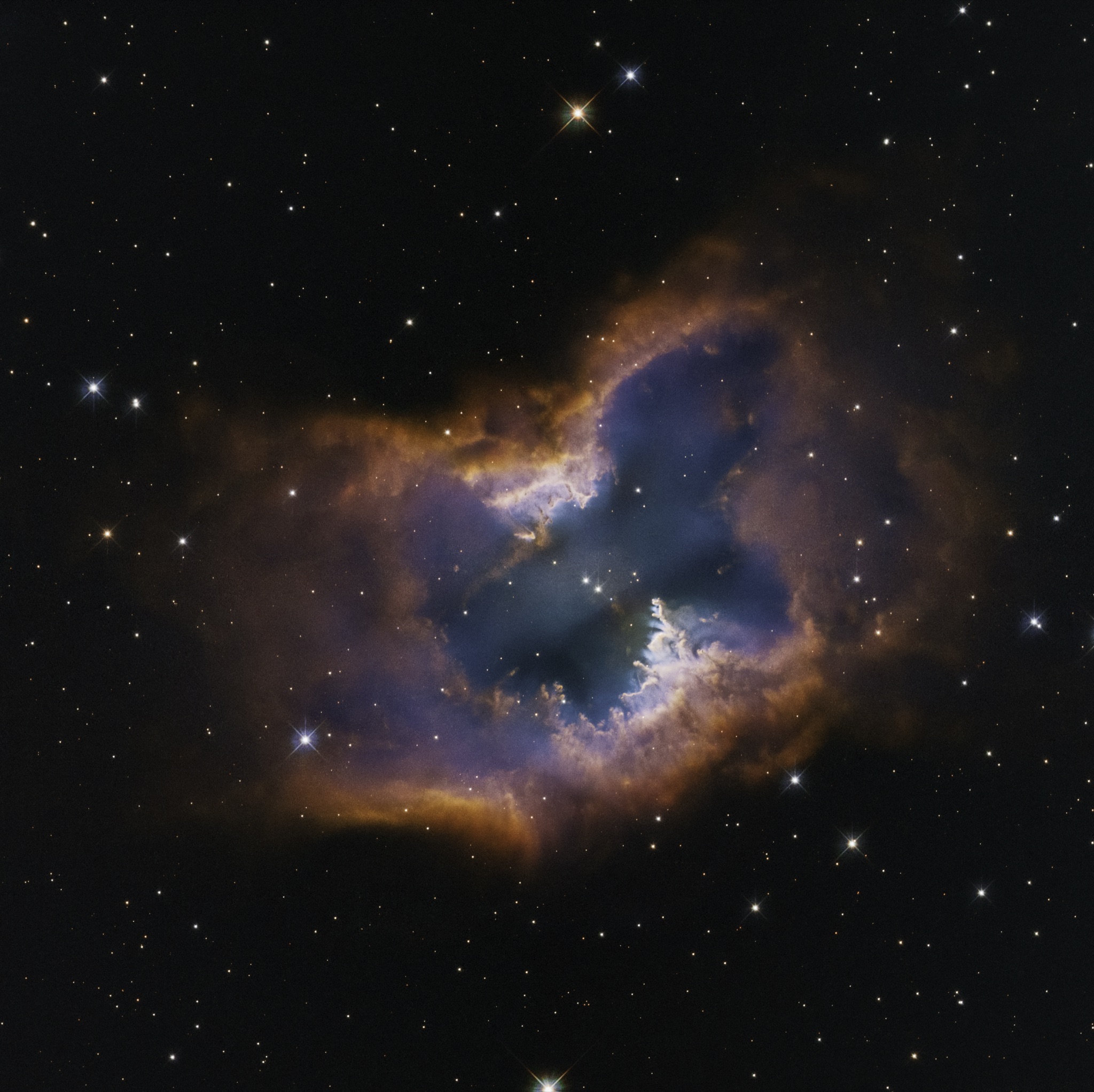 The moth-shaped bipolar planetary nebula NGC 2899, glowing pink and blue lobes of hydrogen and oxygen gas fanning out symmetrically from a hot central white dwarf.